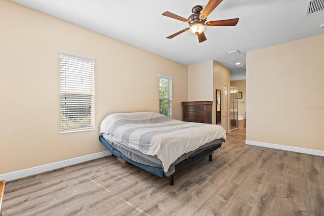 bedroom with light hardwood / wood-style floors, ensuite bath, and ceiling fan