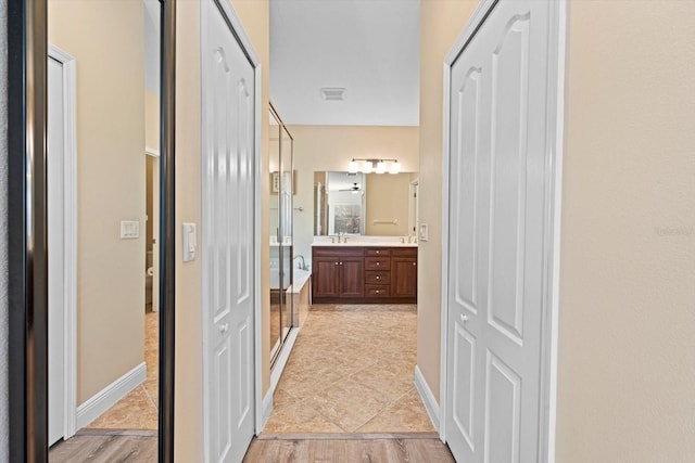 hallway featuring light hardwood / wood-style flooring and sink