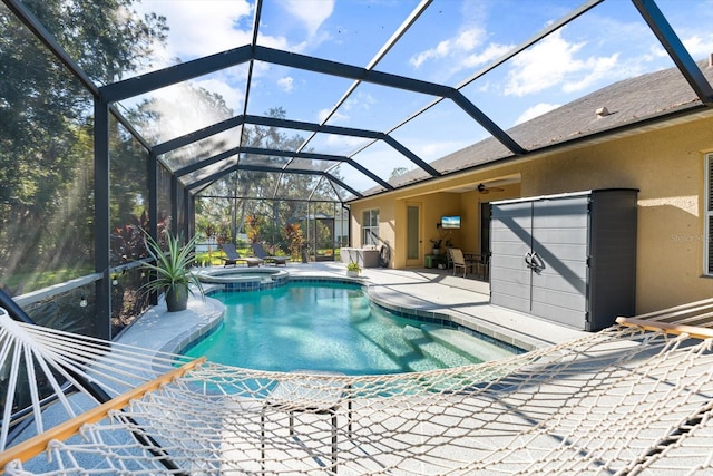 view of swimming pool featuring an in ground hot tub, a patio, glass enclosure, and ceiling fan