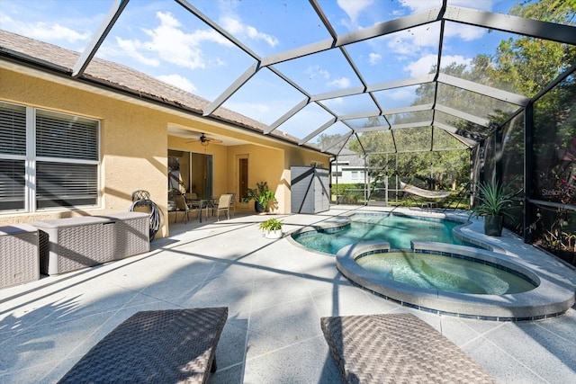 view of swimming pool with a patio, ceiling fan, an in ground hot tub, and glass enclosure