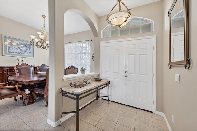 tiled foyer with an inviting chandelier