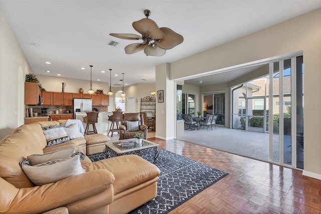 living room with dark parquet floors and ceiling fan