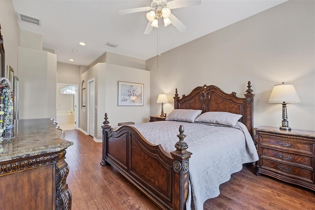 bedroom featuring ensuite bath, dark hardwood / wood-style floors, and ceiling fan