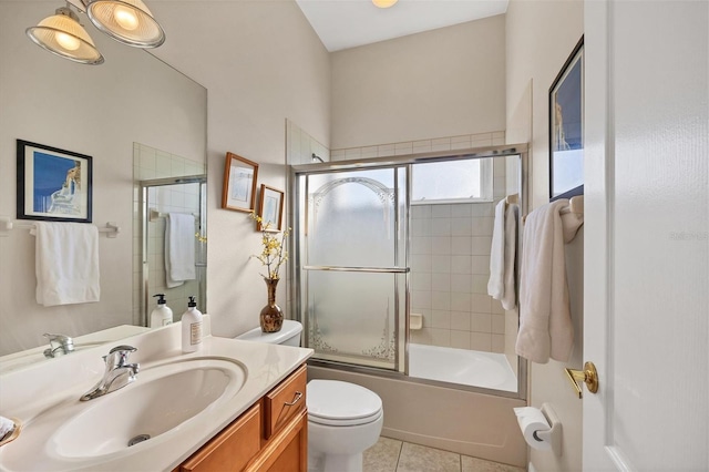 full bathroom featuring vanity, bath / shower combo with glass door, toilet, and tile patterned floors