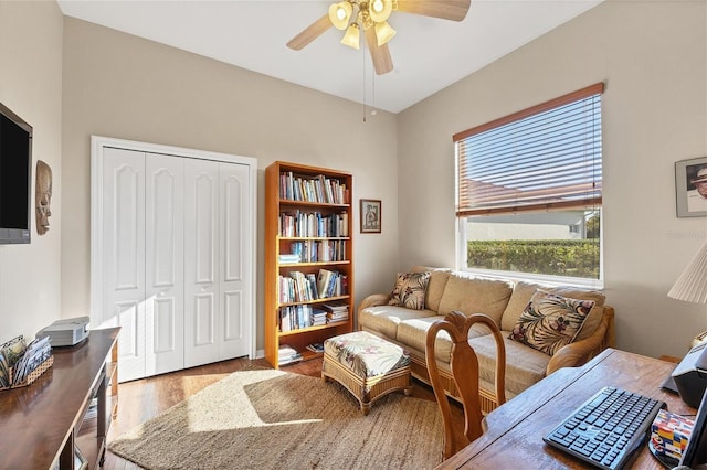 living area with hardwood / wood-style floors and ceiling fan