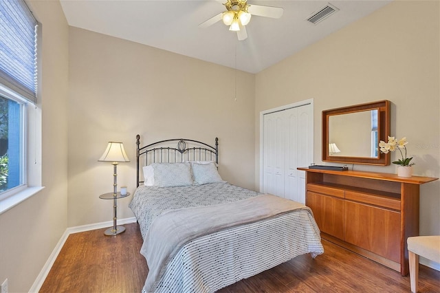 bedroom featuring multiple windows, a closet, wood-type flooring, and ceiling fan