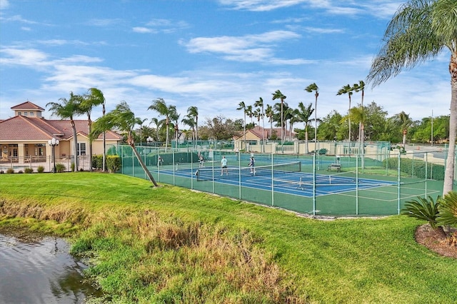 view of sport court featuring a lawn and a water view