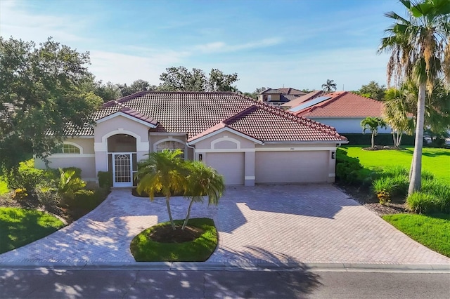 2921 Seasons Blvd, Sarasota, FL 34240 - mediterranean / spanish house with decorative driveway, an attached garage, stucco siding, and a tiled roof