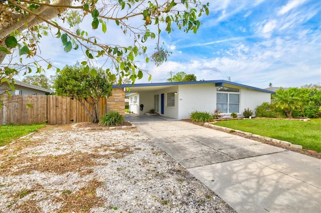 ranch-style house with a front yard and a carport