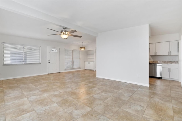 unfurnished living room with beam ceiling, a wealth of natural light, and ceiling fan