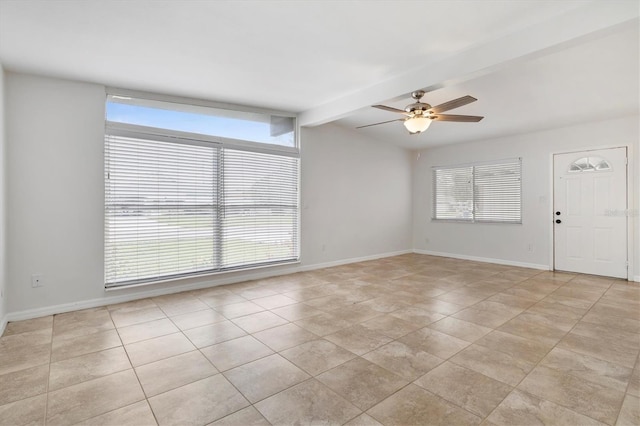 tiled empty room with vaulted ceiling with beams, plenty of natural light, and ceiling fan