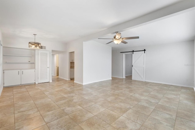 empty room with ceiling fan with notable chandelier and a barn door