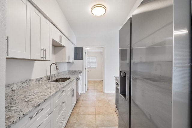 kitchen featuring light stone countertops, white cabinetry, sink, stainless steel appliances, and light tile patterned floors