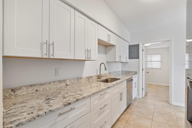 kitchen featuring light stone counters, white cabinetry, stainless steel dishwasher, and sink