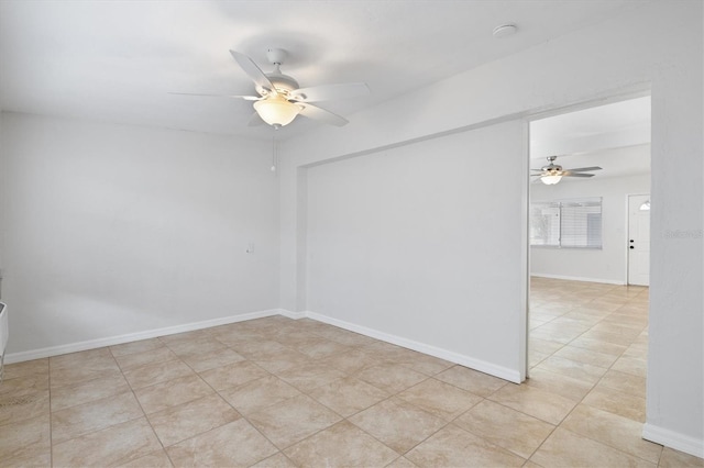 spare room with ceiling fan and light tile patterned flooring