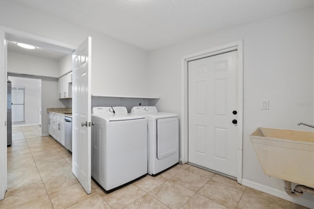 washroom with washing machine and dryer, sink, and light tile patterned floors