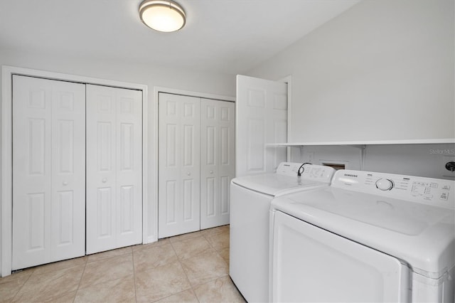 laundry room with light tile patterned floors and washer and clothes dryer