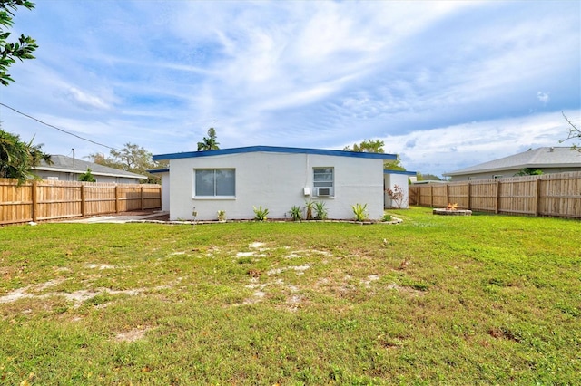 rear view of house with a yard and cooling unit