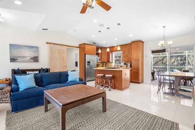 living room with a barn door, lofted ceiling, light tile patterned floors, and ceiling fan with notable chandelier