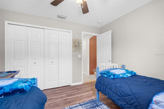 bedroom featuring hardwood / wood-style floors, a closet, and ceiling fan