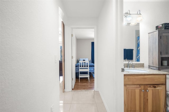 corridor with sink and light tile patterned floors