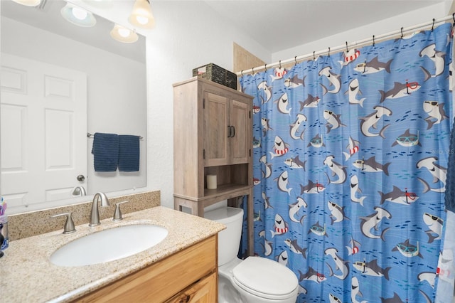 bathroom featuring curtained shower, vanity, and toilet