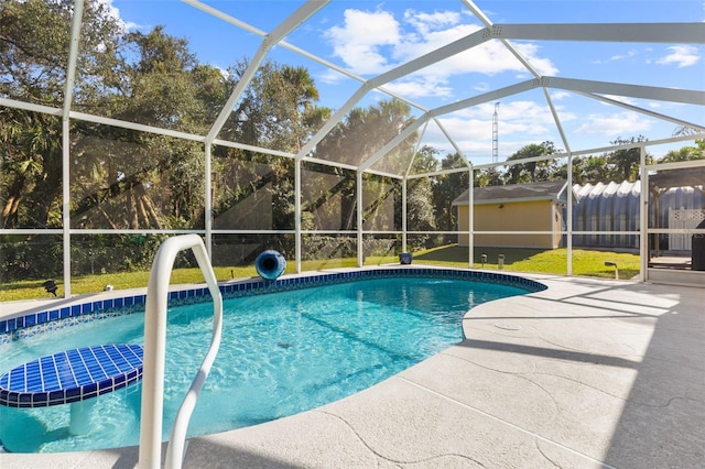 view of swimming pool featuring a patio area, a yard, a storage unit, and a lanai