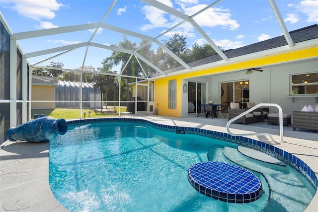 view of swimming pool with a patio, glass enclosure, and ceiling fan