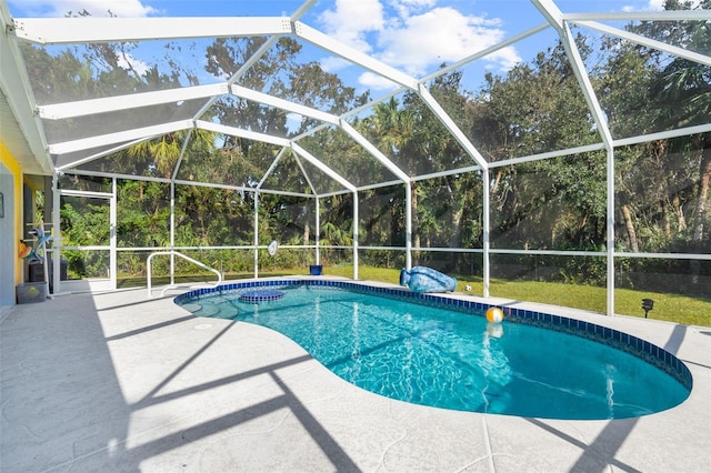 view of swimming pool with glass enclosure and a patio