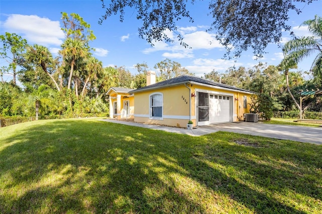 exterior space featuring a front lawn, a garage, and central AC unit