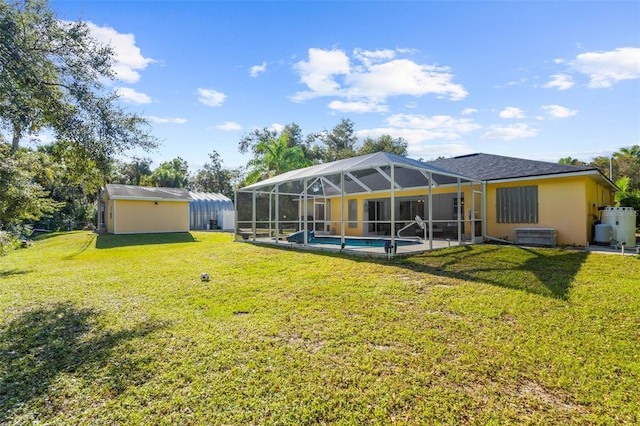 rear view of property with an outbuilding, a lanai, and a lawn