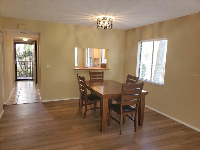 dining area with plenty of natural light, hardwood / wood-style floors, and a textured ceiling