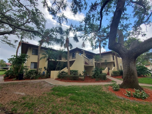 view of front of home featuring a balcony and a front yard