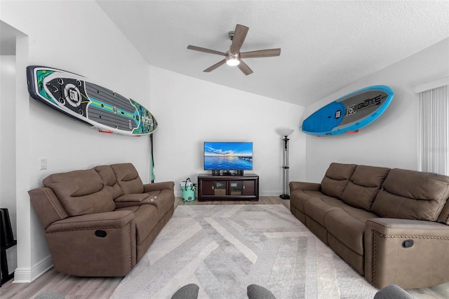 living room featuring vaulted ceiling, light hardwood / wood-style flooring, and ceiling fan