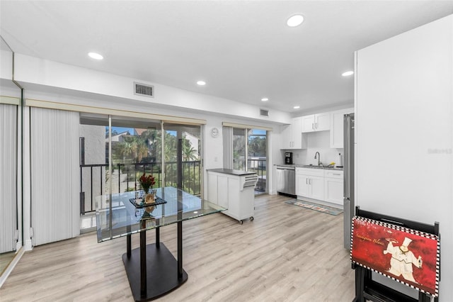 kitchen featuring white cabinetry, appliances with stainless steel finishes, sink, and light wood-type flooring