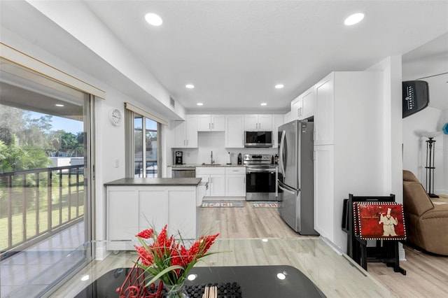 kitchen with sink, stainless steel appliances, light hardwood / wood-style flooring, and white cabinets