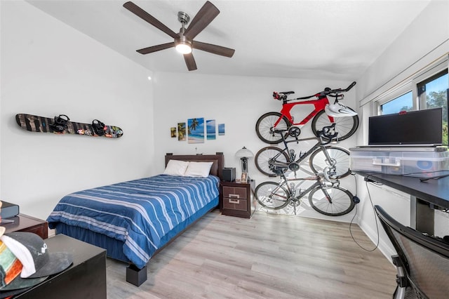 bedroom featuring light hardwood / wood-style flooring, vaulted ceiling, and ceiling fan