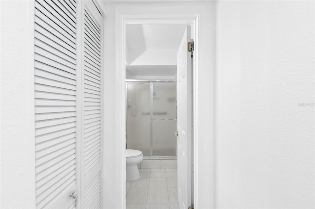 bathroom with toilet, tile patterned floors, and walk in shower