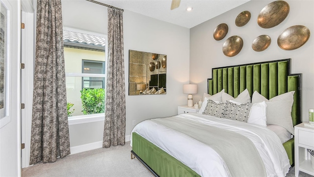 bedroom with ceiling fan and light carpet