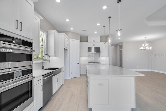 10442 Morning Mist, Sarasota, FL 34241 - kitchen with appliances with stainless steel finishes, decorative backsplash, light wood finished floors, a sink, and light countertops