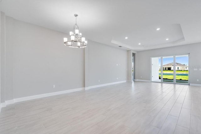 10442 Morning Mist, Sarasota, FL 34241 - spare room featuring a raised ceiling, a chandelier, baseboards, light wood-type flooring, and recessed lighting