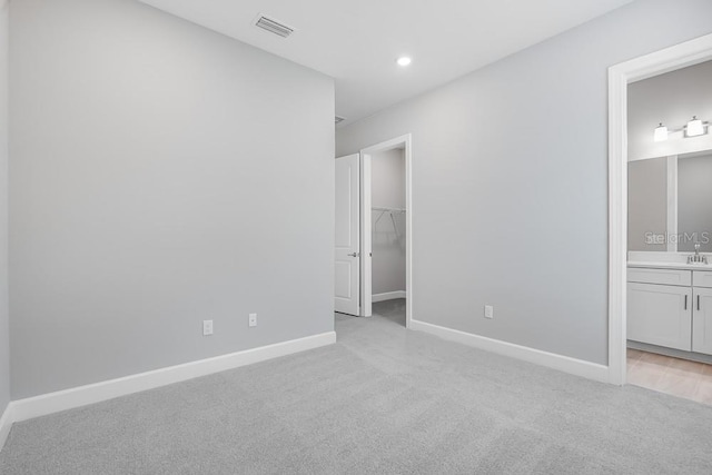 10442 Morning Mist, Sarasota, FL 34241 - unfurnished bedroom featuring light carpet, a walk in closet, baseboards, connected bathroom, and recessed lighting