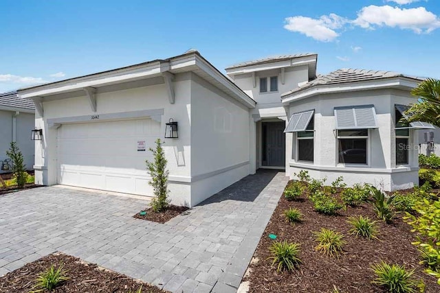 10442 Morning Mist, Sarasota, FL 34241 - view of front of home featuring an attached garage, stucco siding, and decorative driveway