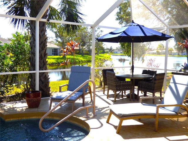 view of patio featuring glass enclosure and a water view