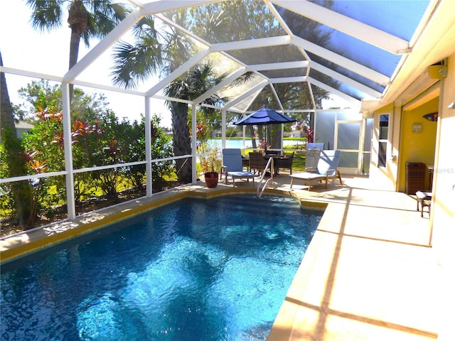 view of pool featuring glass enclosure and a patio