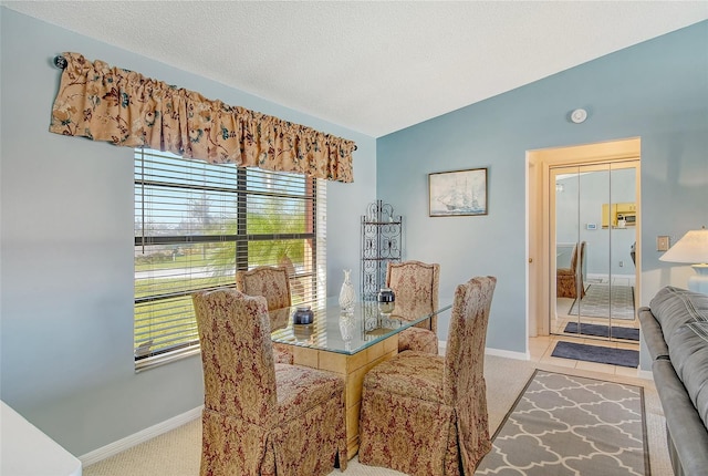 dining area featuring light carpet, lofted ceiling, and a textured ceiling