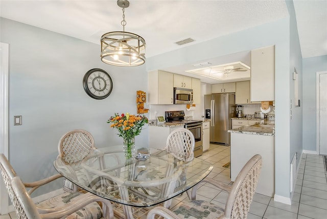 tiled dining space featuring a notable chandelier