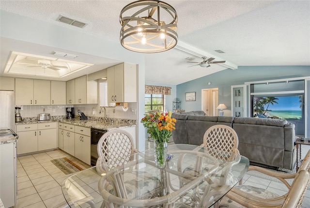 tiled dining room featuring vaulted ceiling with beams, a textured ceiling, sink, and ceiling fan with notable chandelier