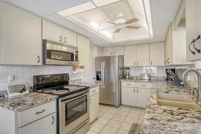 kitchen featuring tasteful backsplash, sink, white cabinetry, ceiling fan, and stainless steel appliances