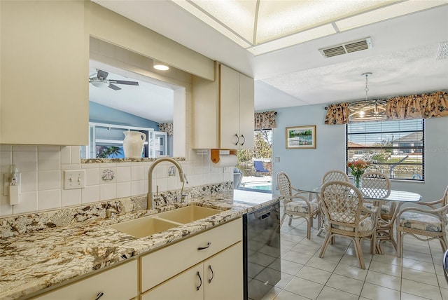 kitchen with black dishwasher, cream cabinets, sink, and a wealth of natural light